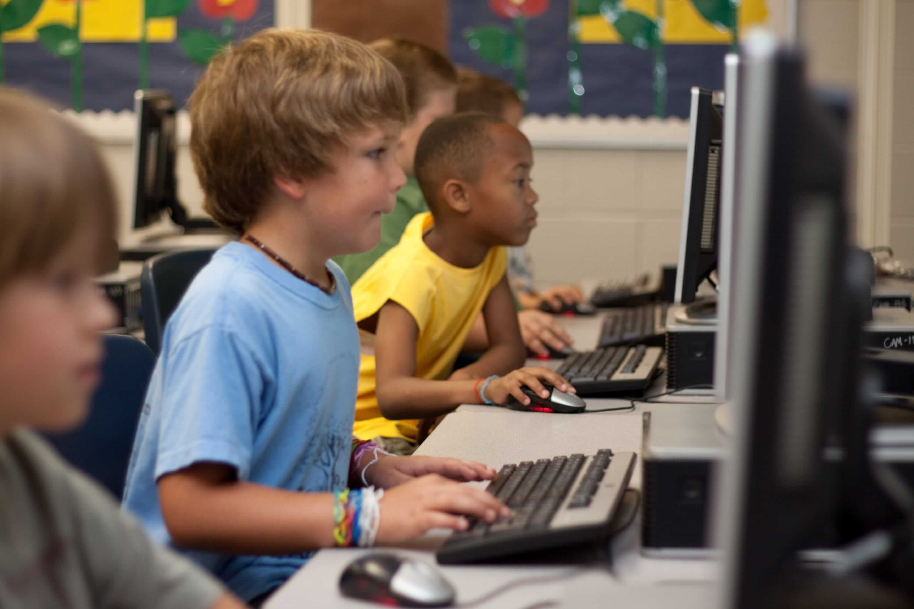 Boy sits in front of the computer, playing an educational game | Gamification in eLearning